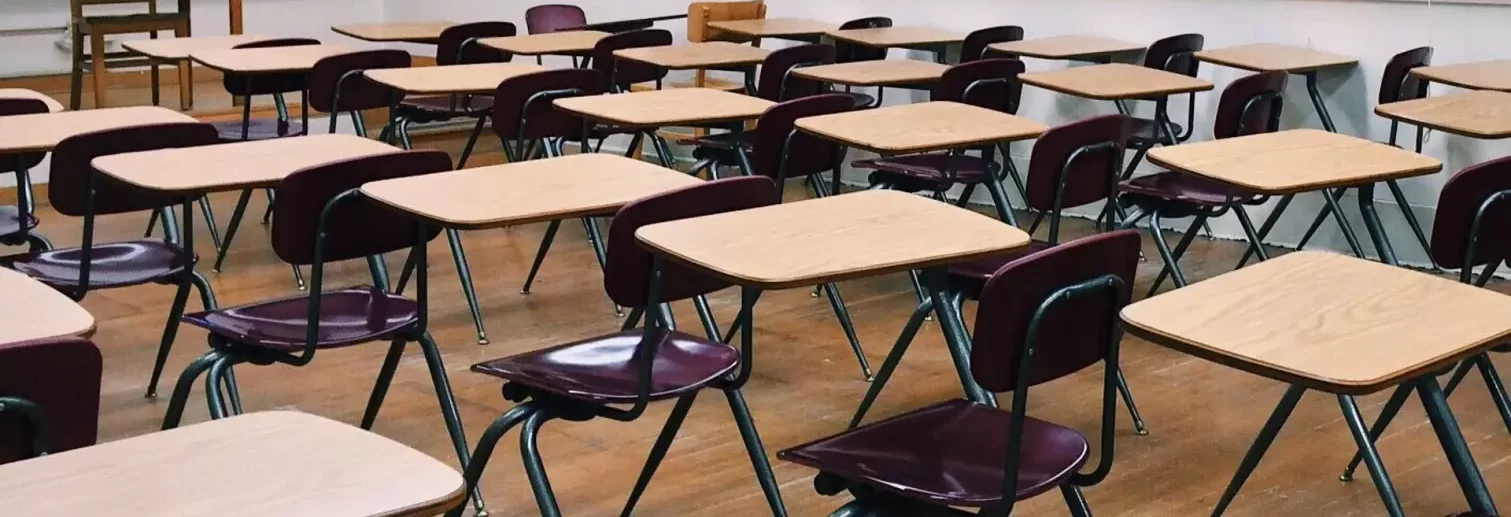 salle de classe avec tables et chaises en rang d'oignon